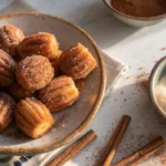 Baked churro bites on a plate with cinnamon sugar